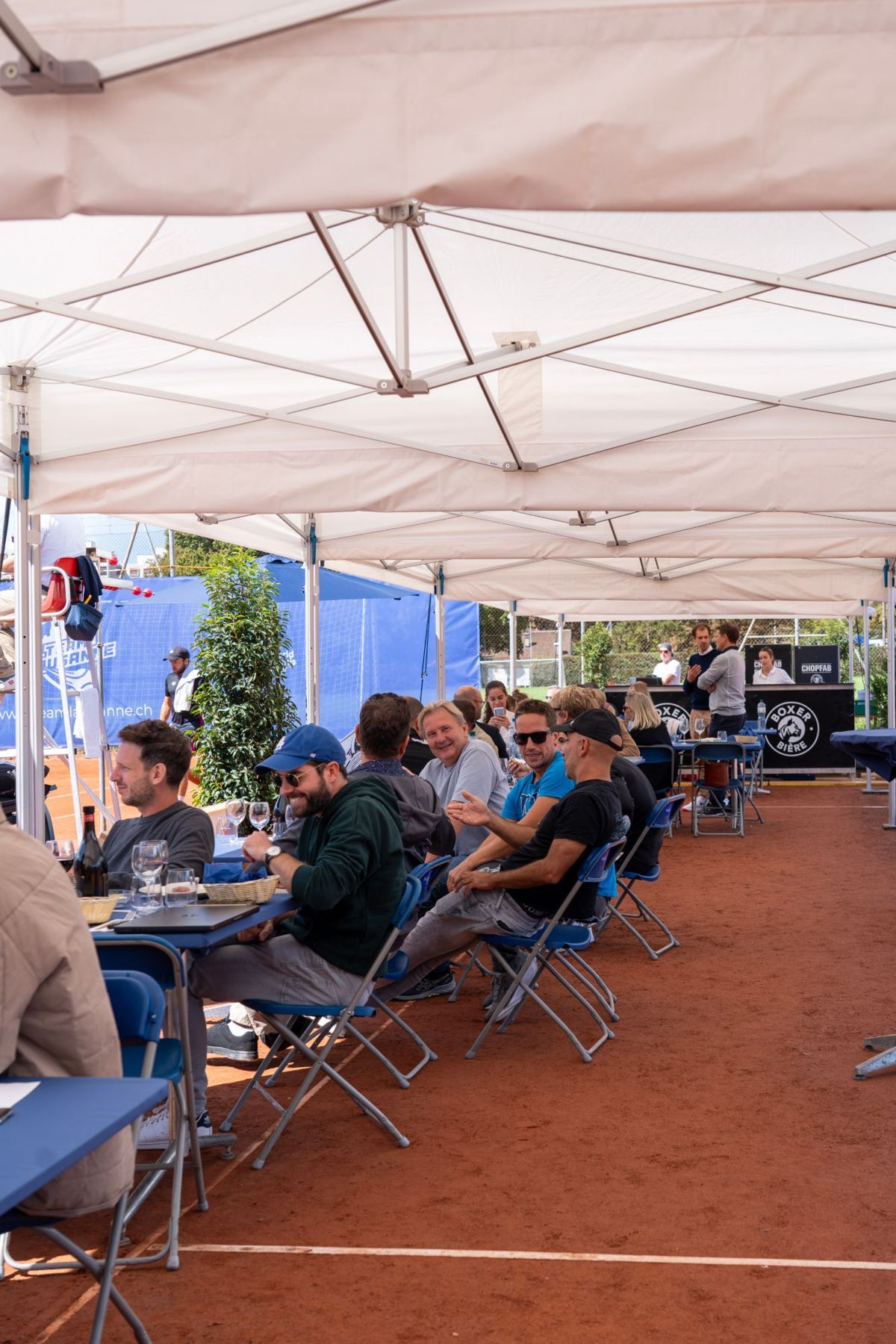 Tables de l'espace hospitalité au bord des courts